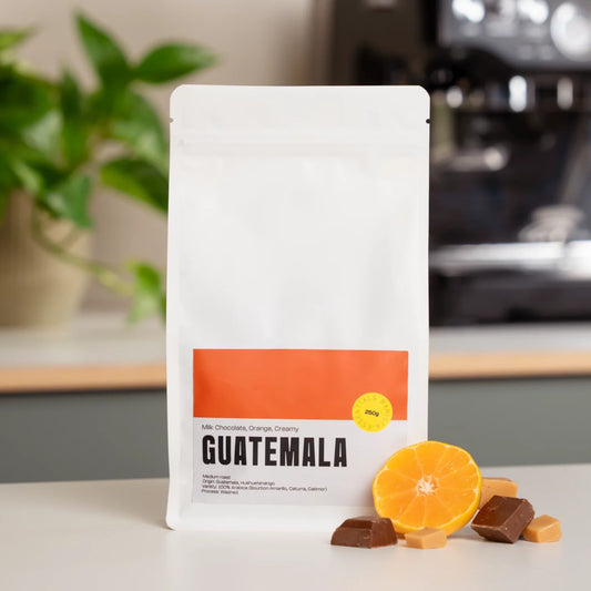 Zak Guatemala koffiebonen op een keukenblad met een sinaasappel