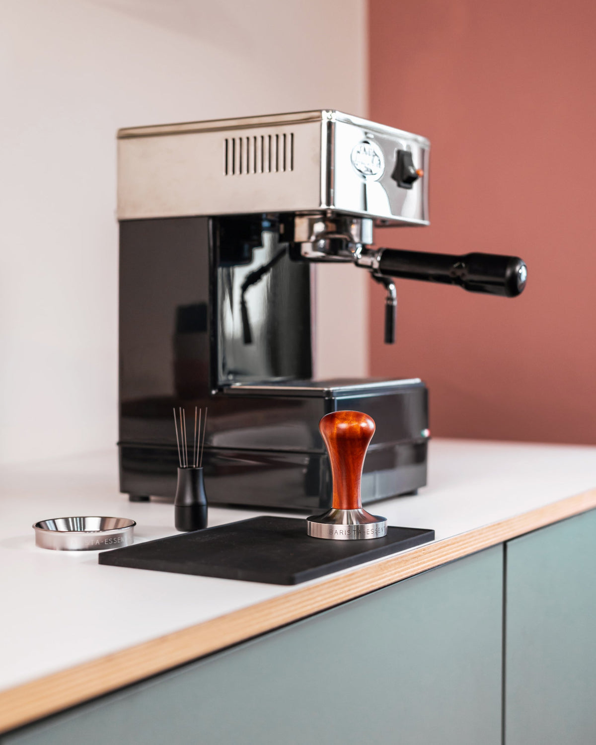 Houten tamper op een werkblad bij een espressomachine