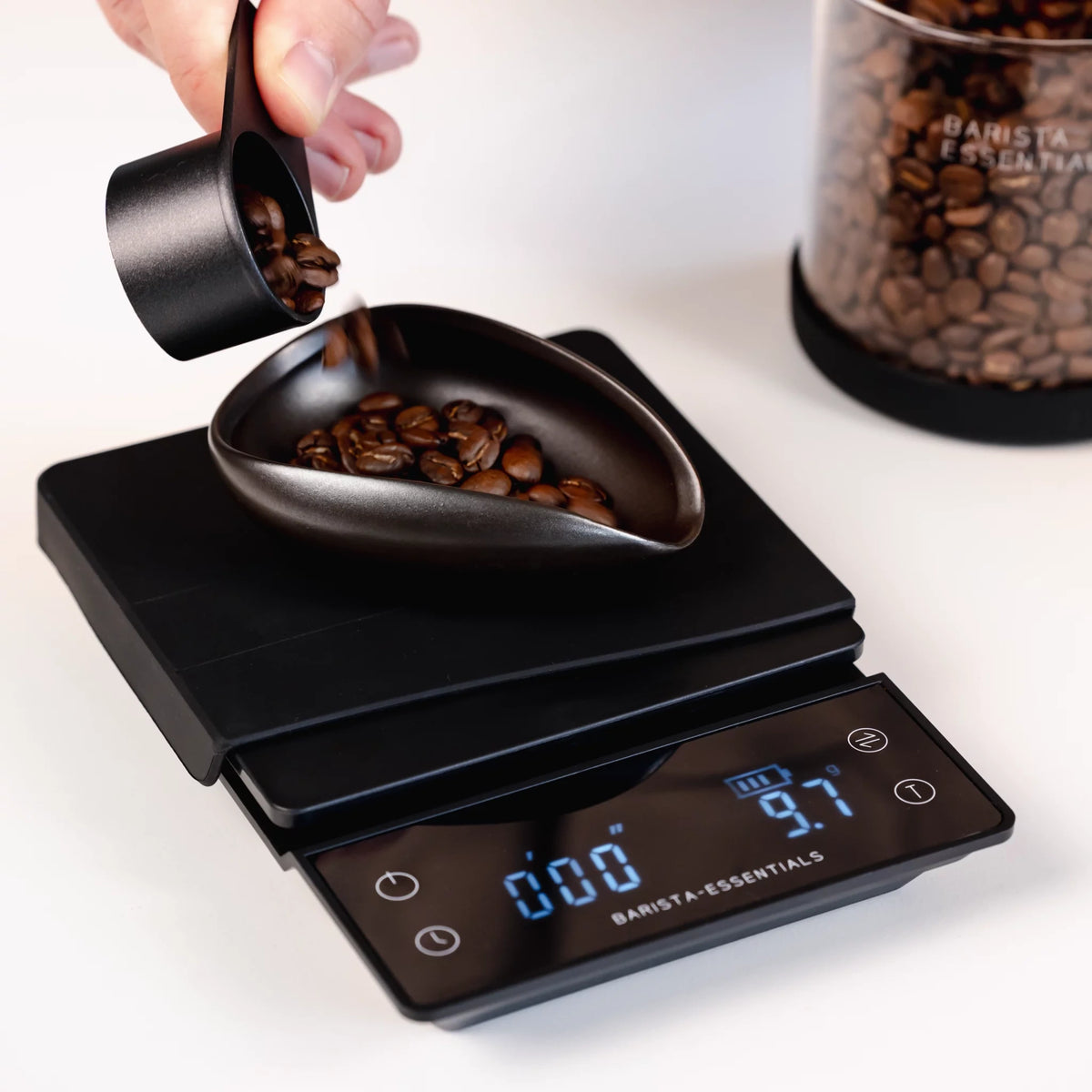 Koffiebonen worden in een doseerschaal op een weegschaal geschonken