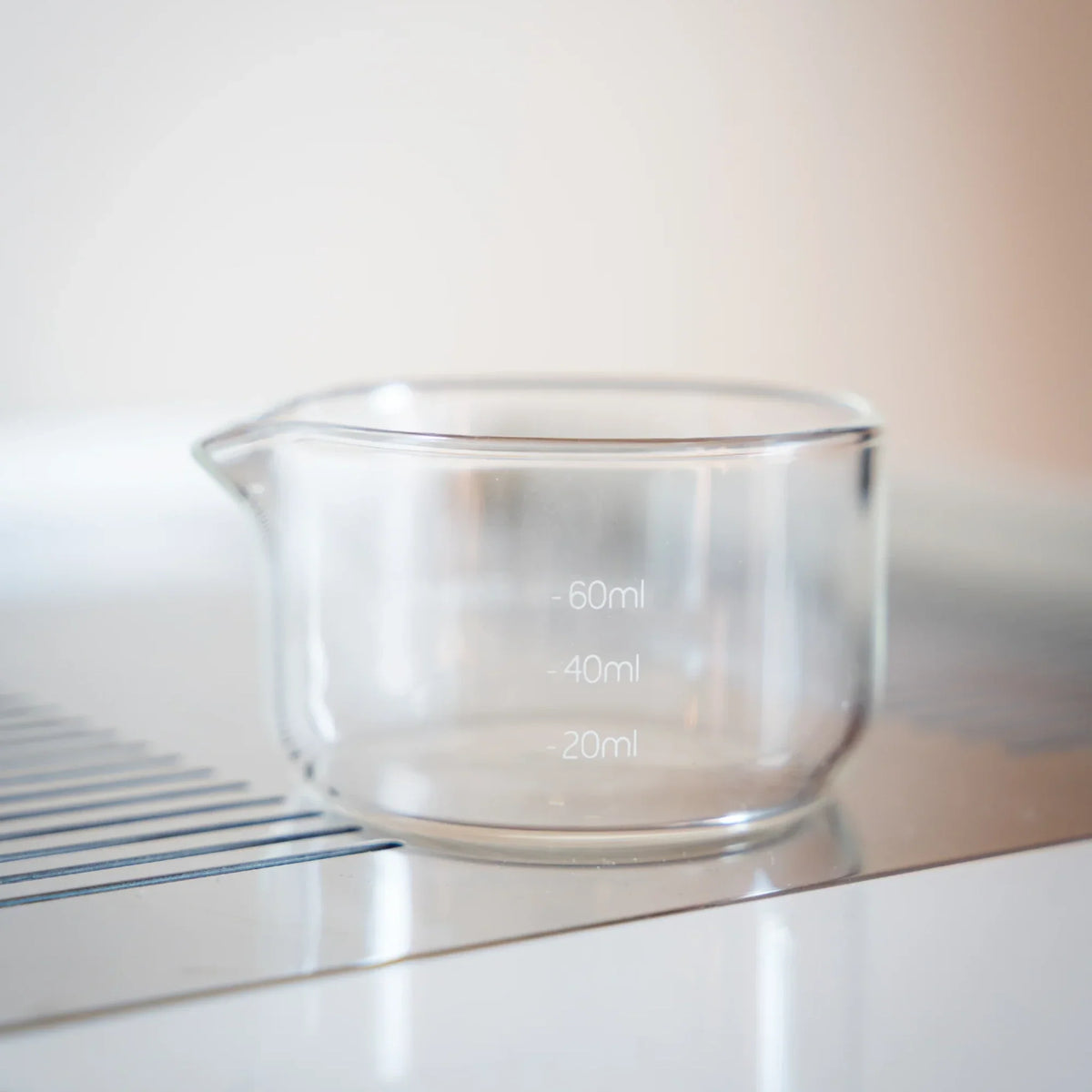 Espresso shotglas onder een portafilter op een weegschaal om output en doorlooptijd te meten bij espresso thuis.