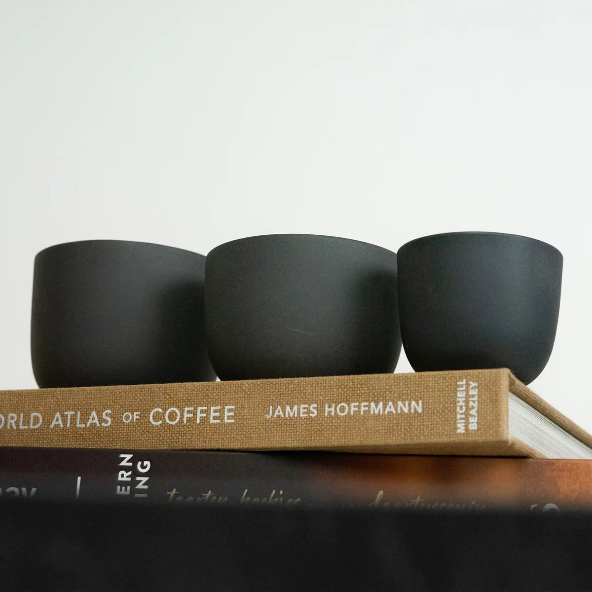 Drie grijze keramische koffiekopjes voor espresso, cappuccino en latte op The World Atlas of Coffee