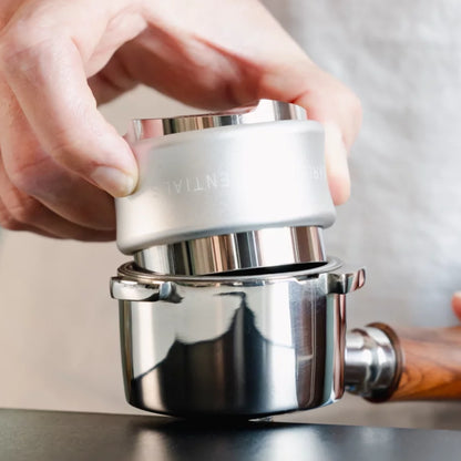 Hand gebruikt de zilveren combinatietool in een filterbakje