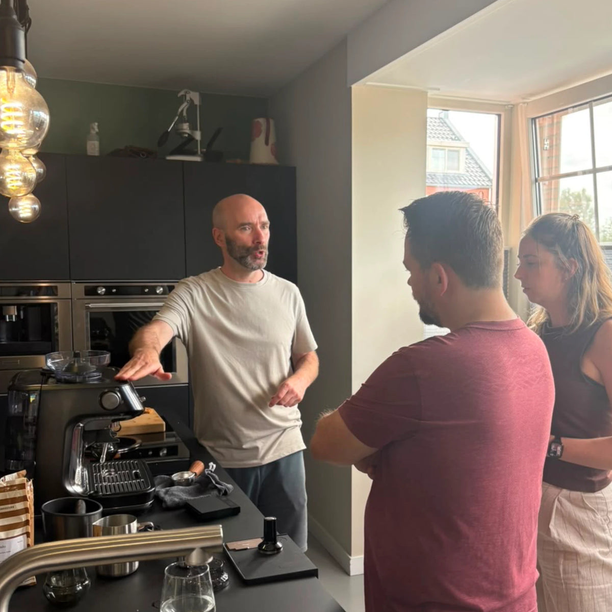 Geert-Jan de Baristaman geeft twee deelnemers uitleg over het gebruik van hun Sage Barista Pro tijdens een barista workshop aan huis op de eigen espressomachine.