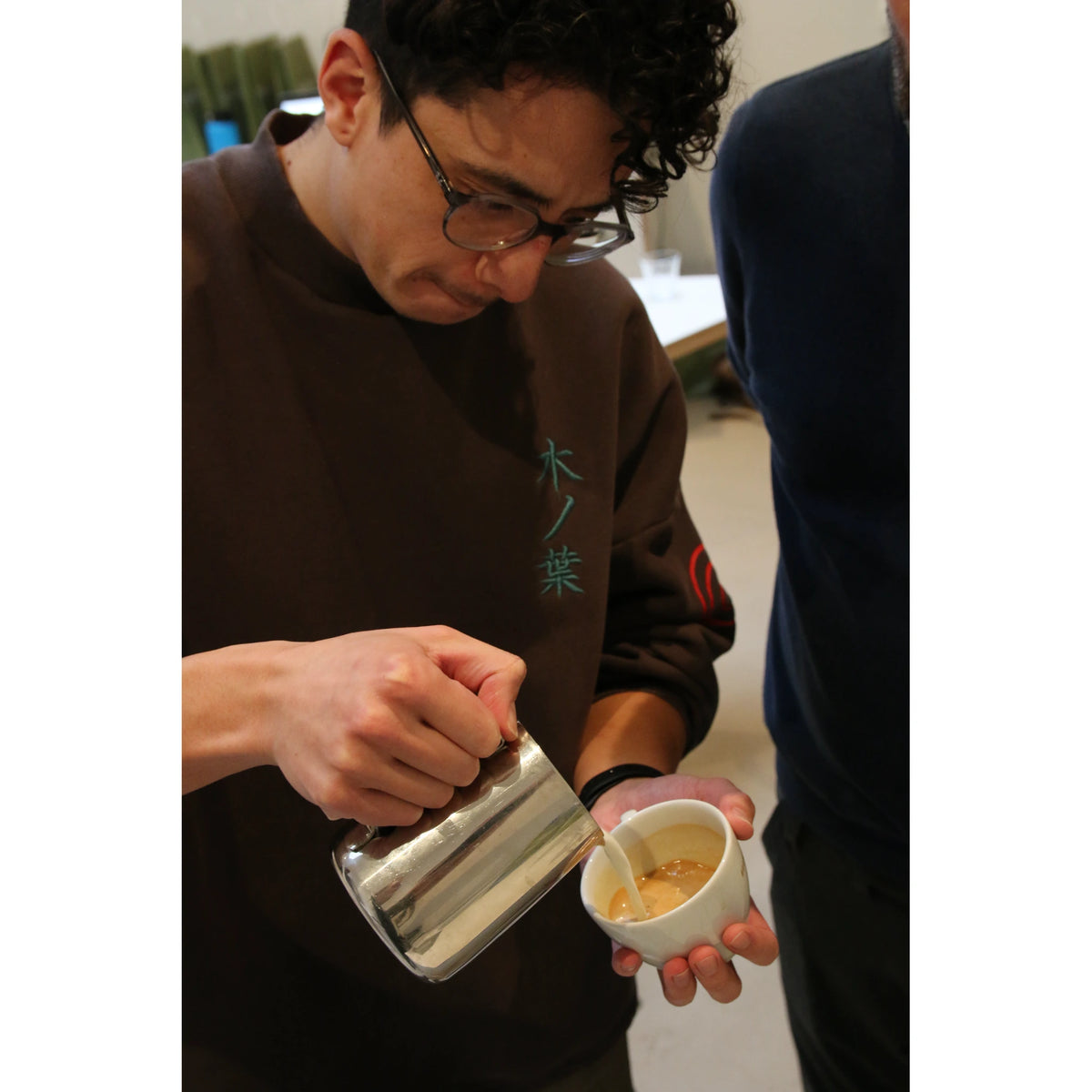 Workshop deelnemer stelt een espressomolen af voor de ideale maling tijdens de Barista Workshop in Amsterdam.
