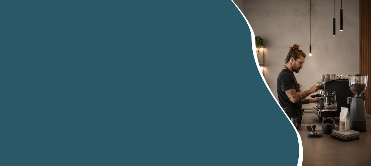Hero banner van een barista workshop voor bedrijven met espressomachine, koffiemolen en melkkan op locatie