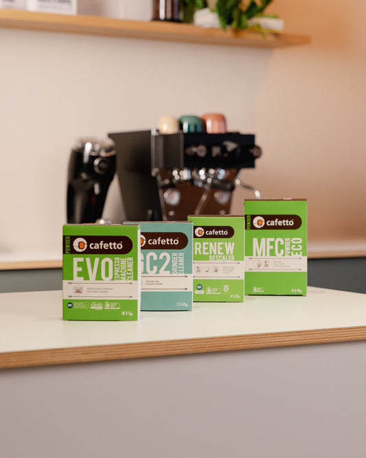 Cafetto onderhoudsproducten naast een espressomachine; EVO staat vooraan