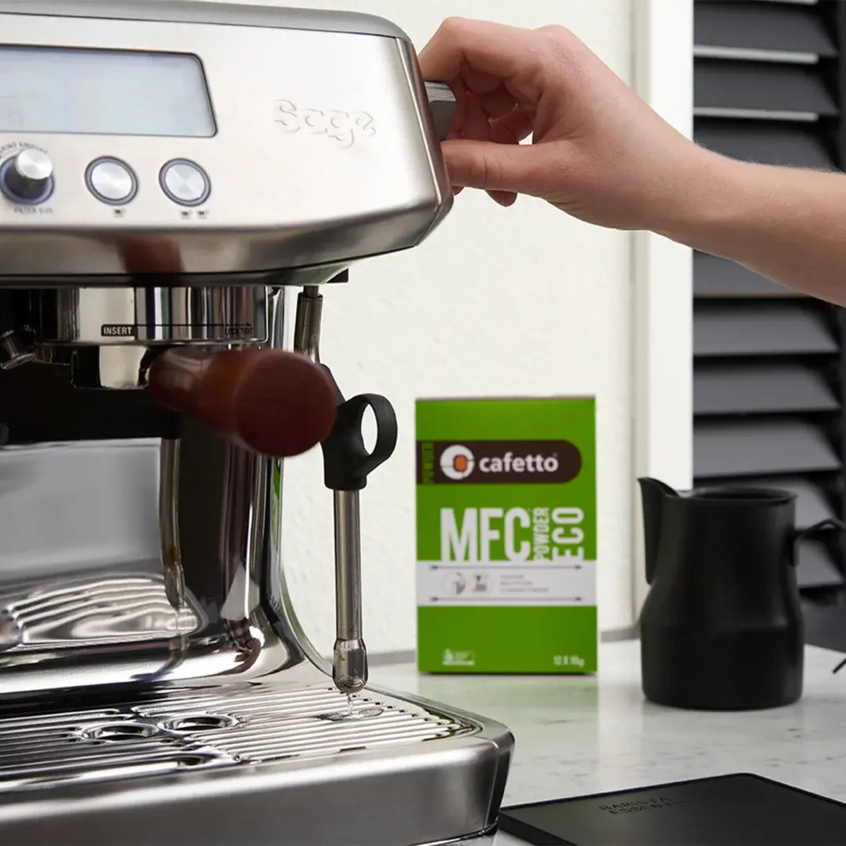 Cafetto MFC Powder Eco naast een espressomachine en zwarte kan