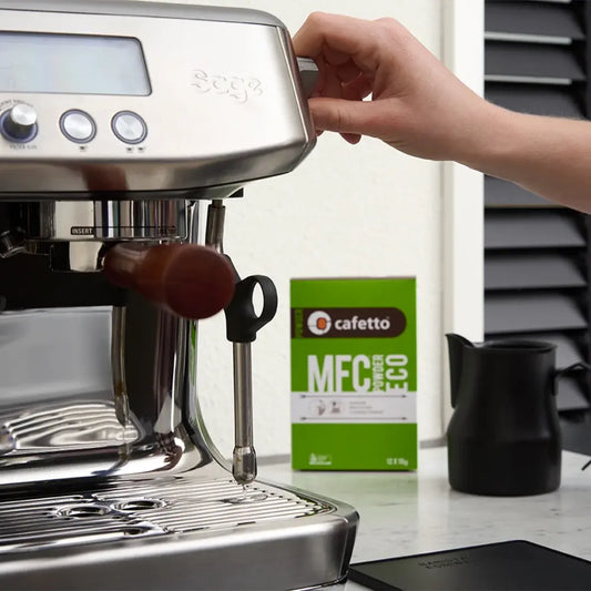 Cafetto MFC Powder Eco naast een espressomachine en zwarte kan