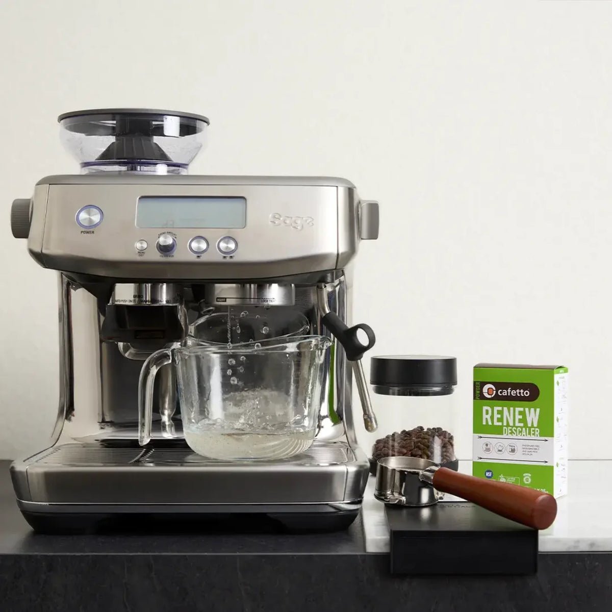 Cafetto Renew naast een espressomachine met glazen opvangkan