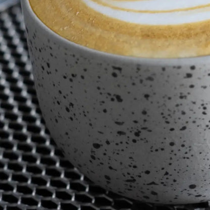 Close-up van melkdrank met latte art in een gestippeld kopje