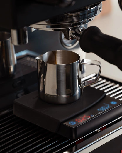 Espressokannetje op een koffie weegschaal onder de filterdrager