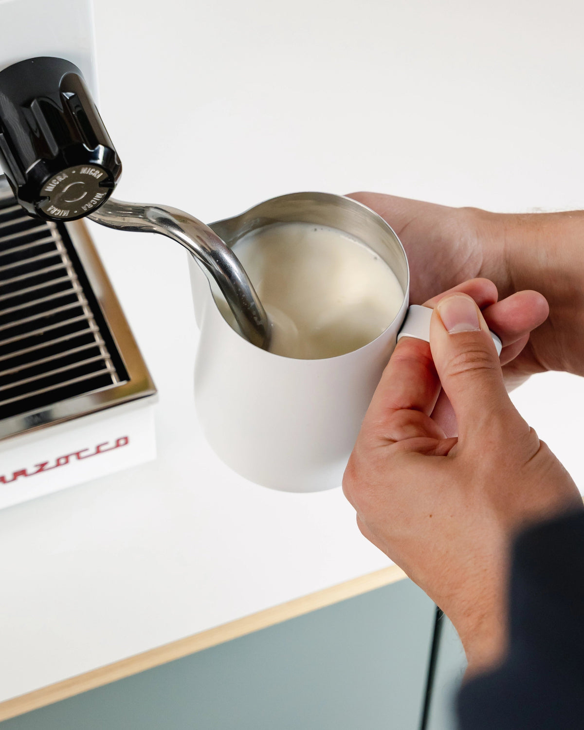 Witte Essentials melkkan onder de stoompijp, van dichtbij