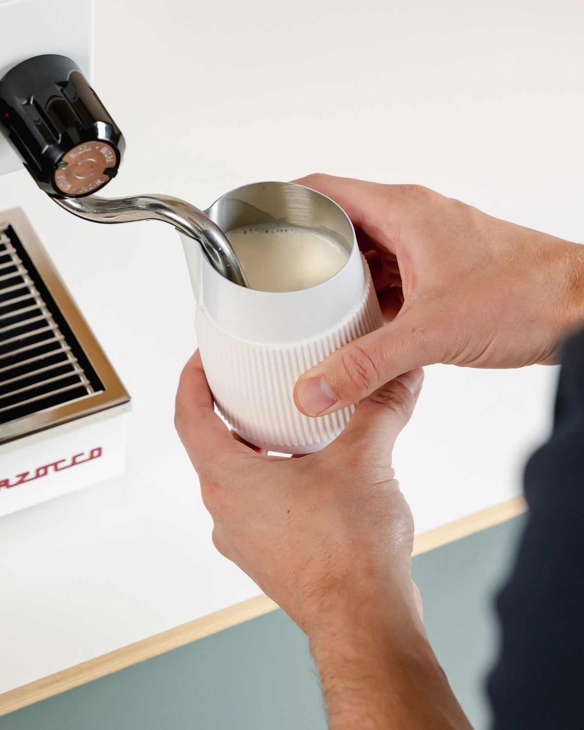 Melk opschuimen in een witte handvatloze melkkan