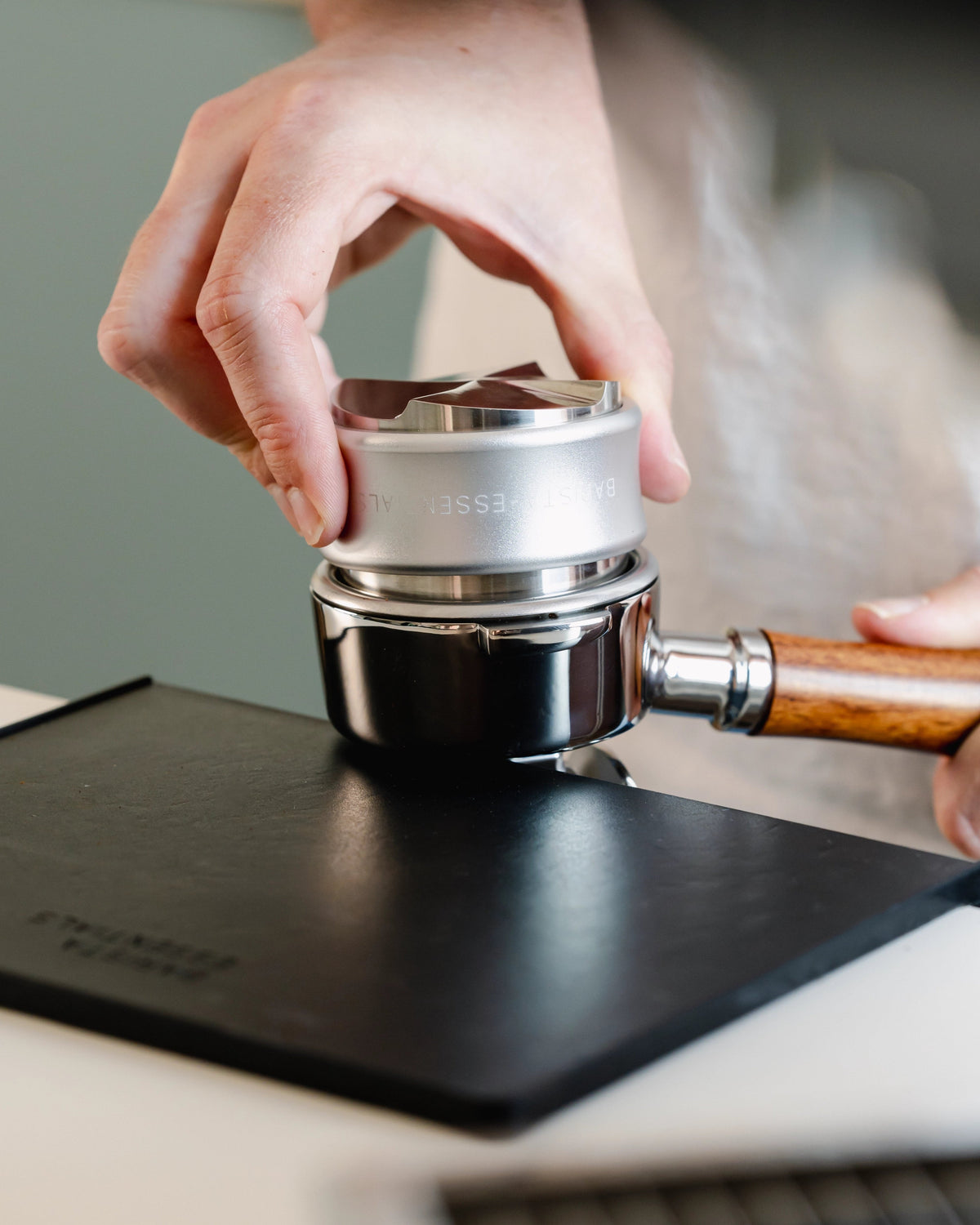Koffie aandrukken met de zilveren tamperzijde van 58,5 mm