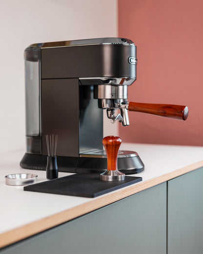 Tamper hout naast een espressomachine
