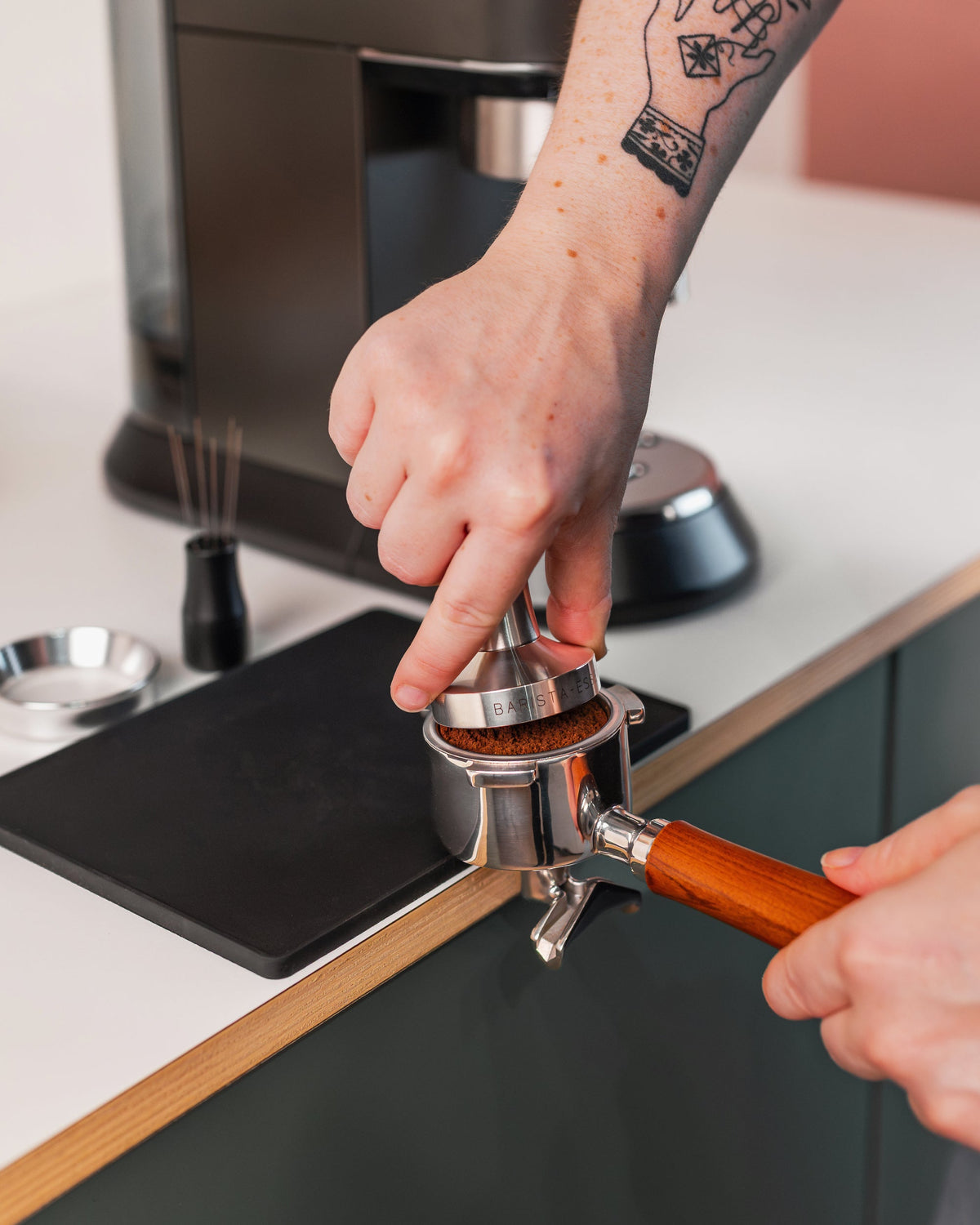 Hand op de rvs tamper tijdens het tampen