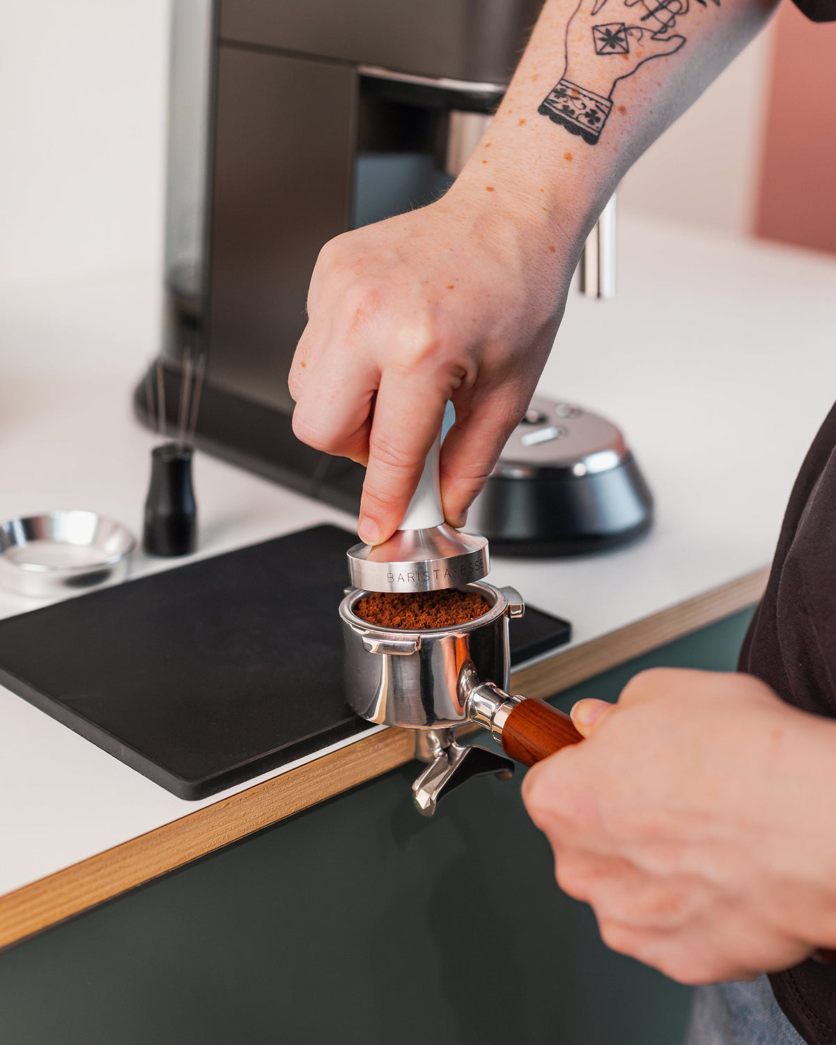 Hand op de wit tamper tijdens het tampen