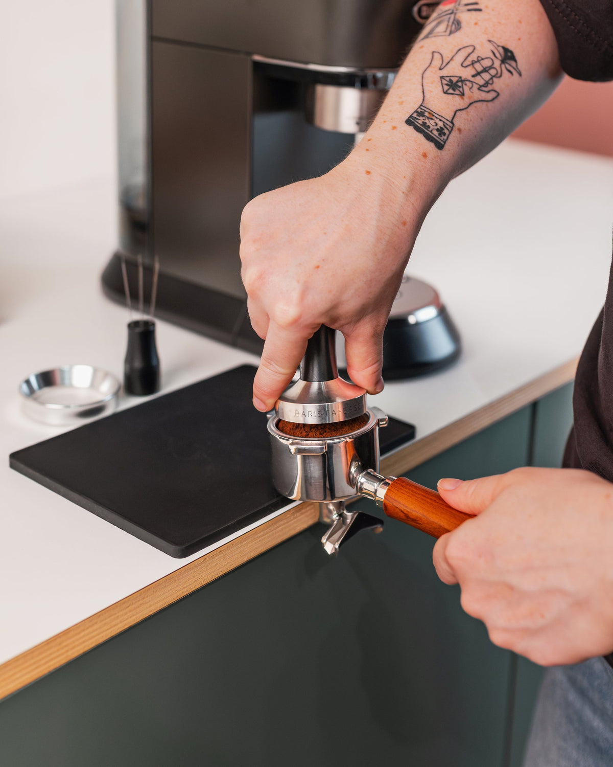 Hand op de zwart tamper tijdens het tampen