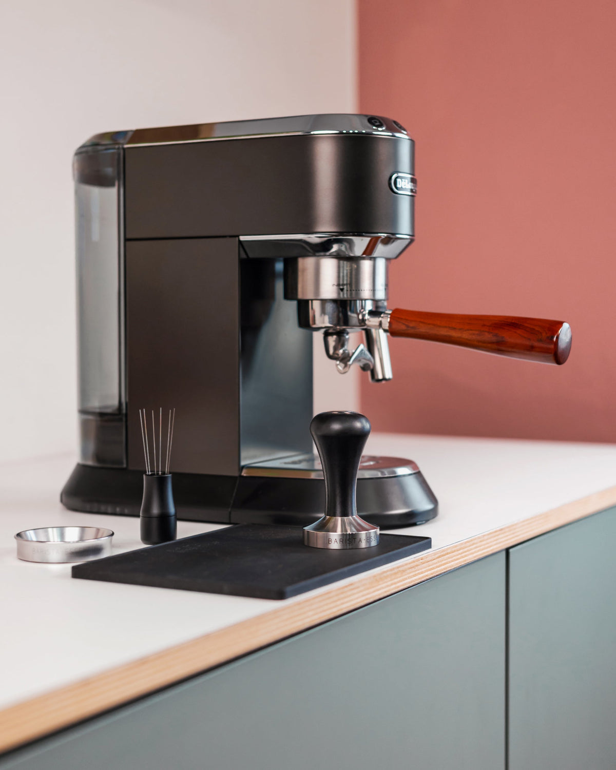 Tamper zwart naast een espressomachine