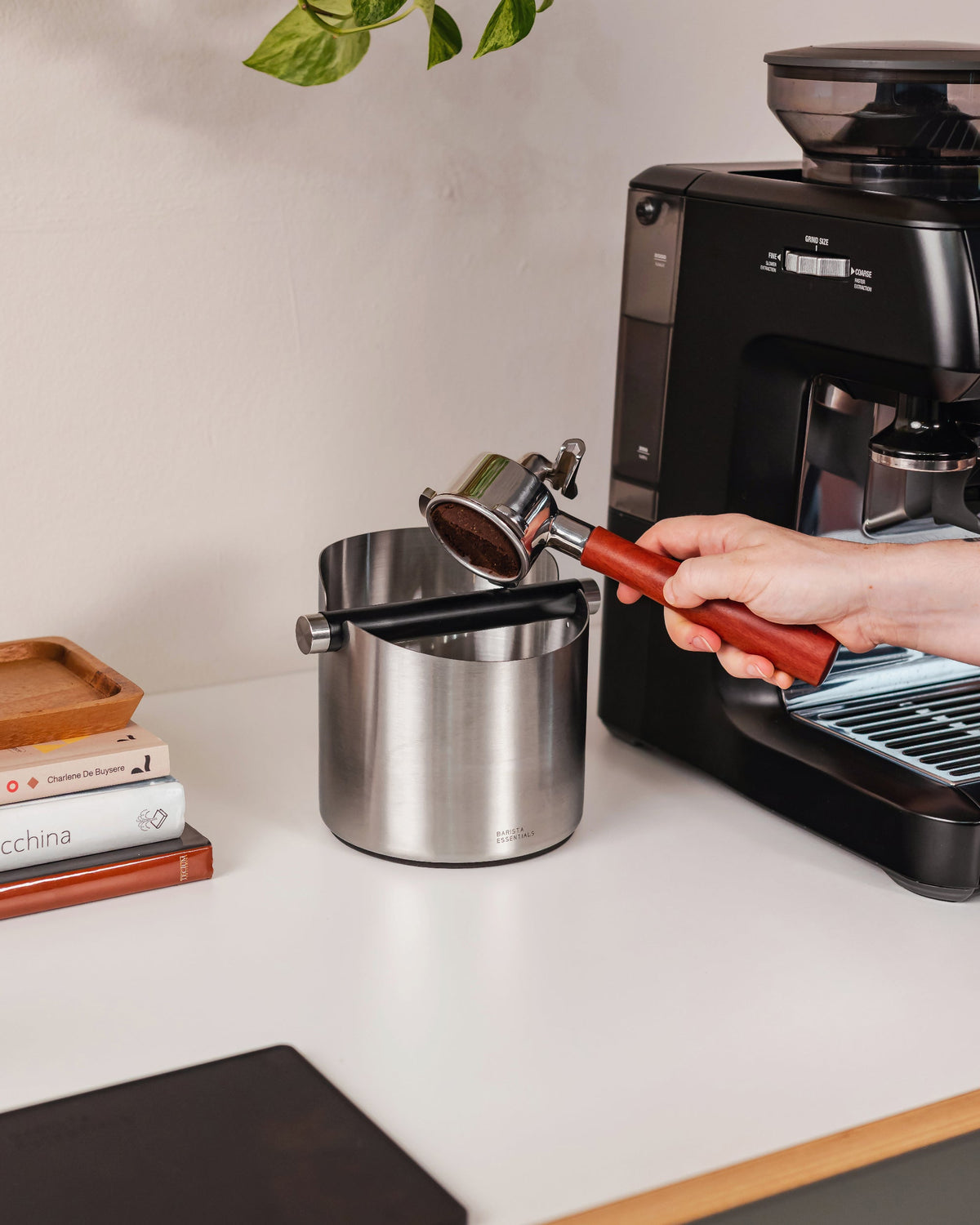 14 cm zilveren uitklopbak tijdens het uitkloppen van een koffiepuck