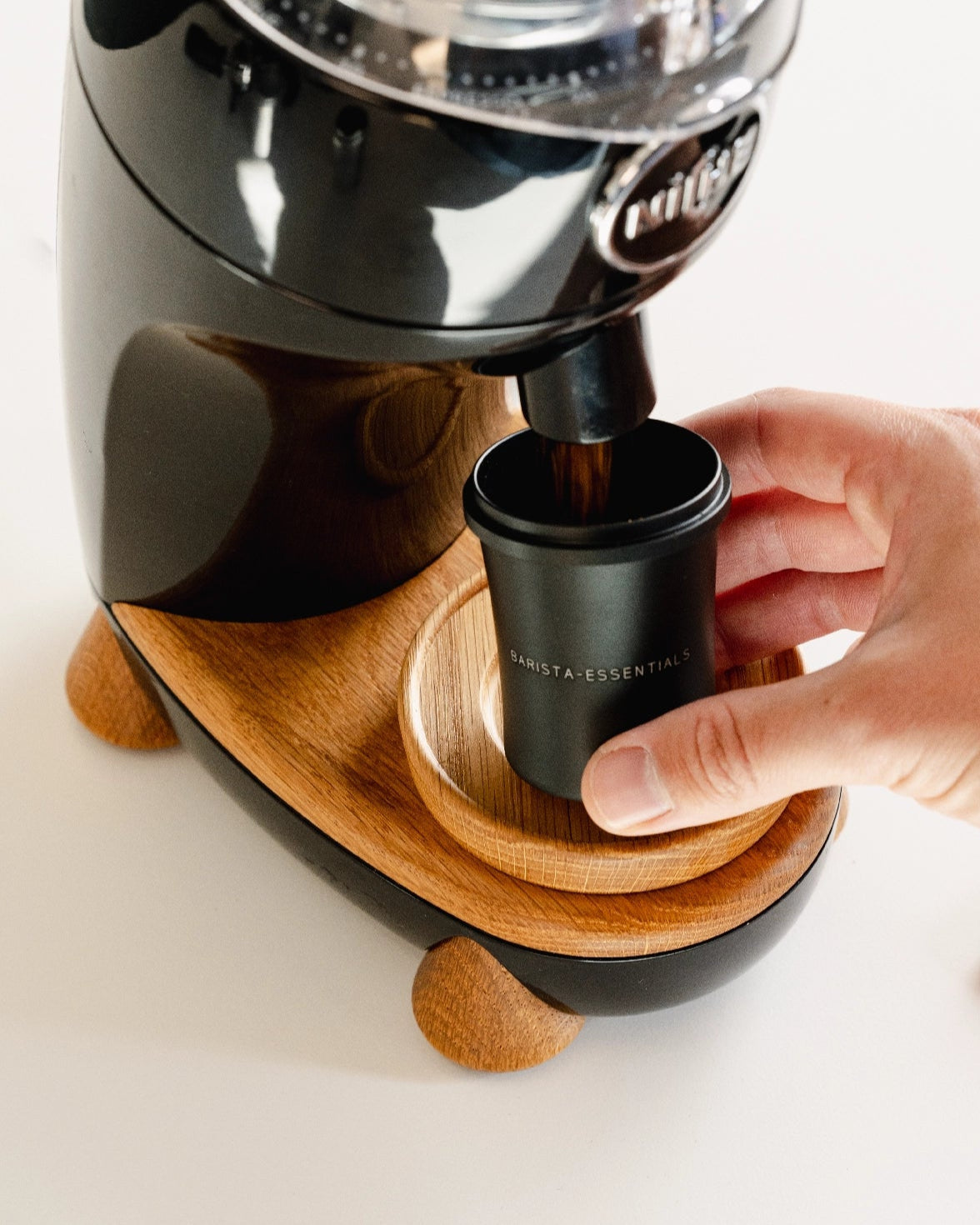 Zwarte 51 mm doseerbeker onder een koffiemolen