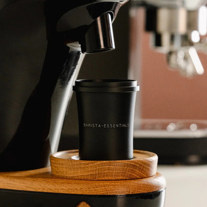 Zwarte 51 mm doseerbeker onder de koffie-uitloop van een molen