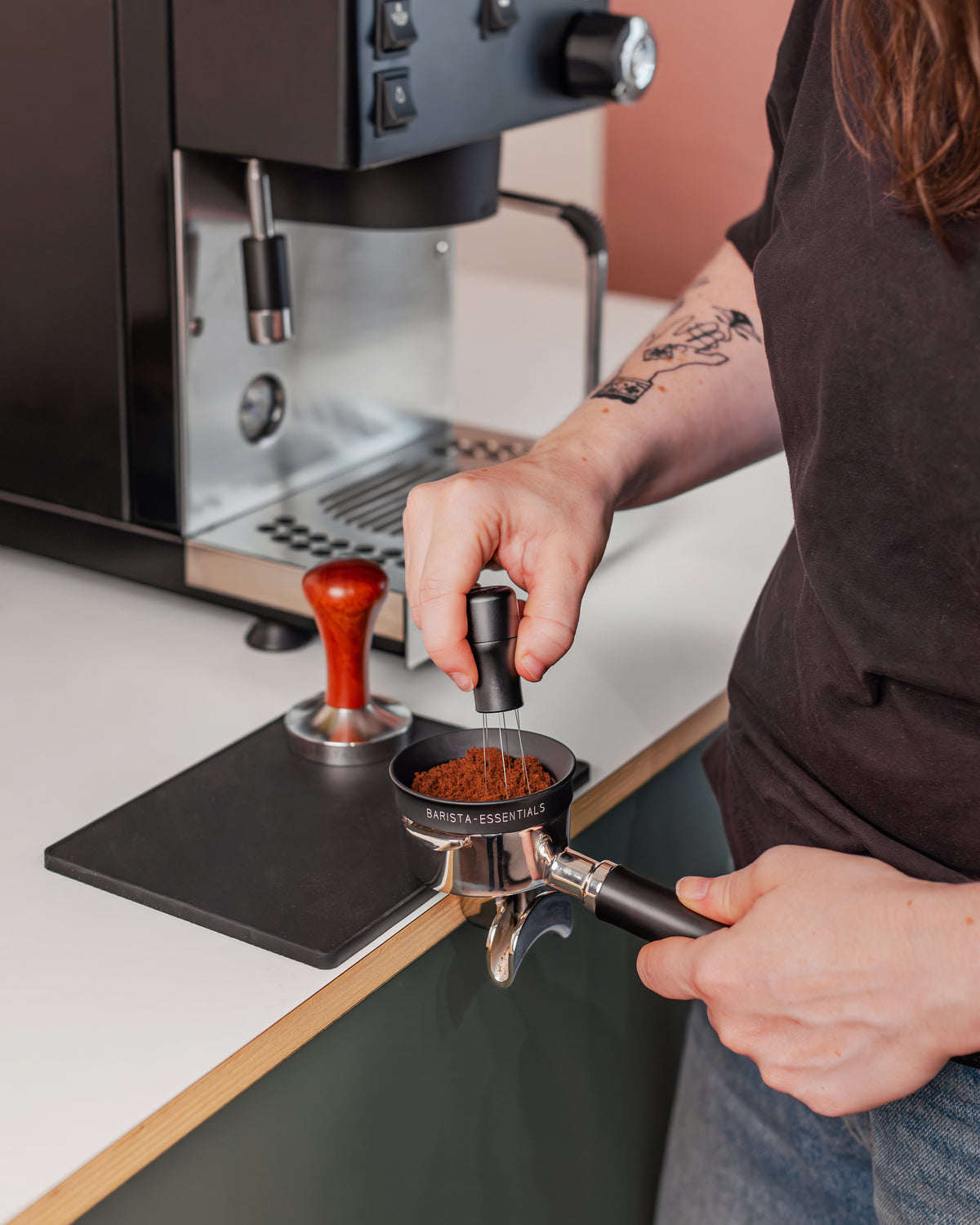 Zwarte doseerring van 58,5 mm tijdens het verdelen van koffie in een filterdrager
