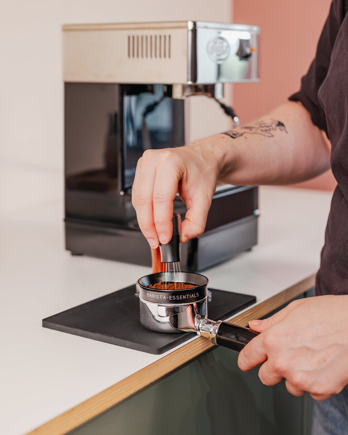Zwarte doseerring van 58 mm tijdens het verdelen van gemalen koffie in een filterdrager
