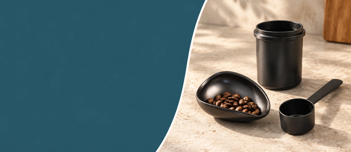 Zwarte doseerbeker, keramisch doseerschaaltje met koffiebonen en koffieschepje