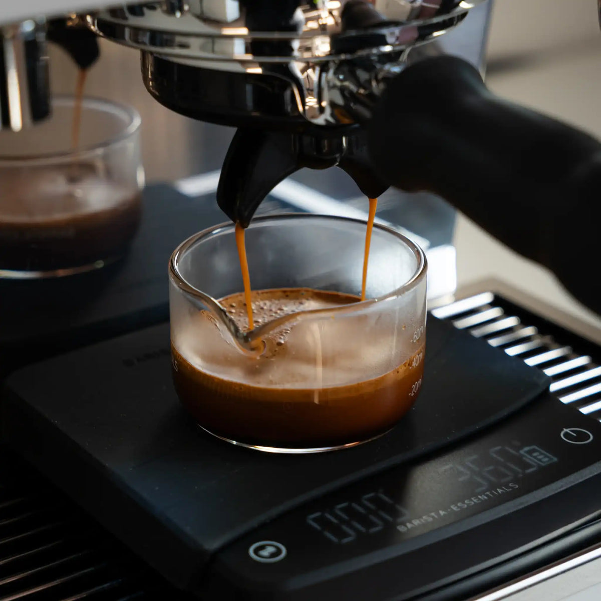 Dubbele espresso extractie van 60 ml in shotglas op weegschaal met controle van doorlooptijd tussen 25 en 30 seconden