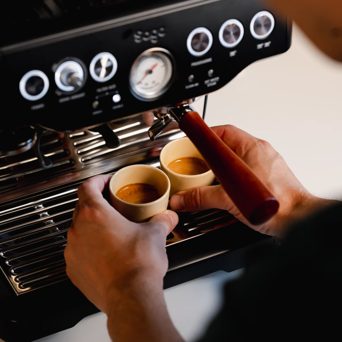 Barista gebruikt zandgeel half-glazed espresso kopje bij het zetten