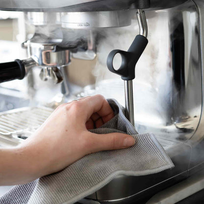 Hand neemt met een grijze doek de stoompijp af