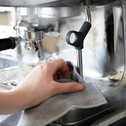 Hand neemt met een grijze doek de stoompijp af