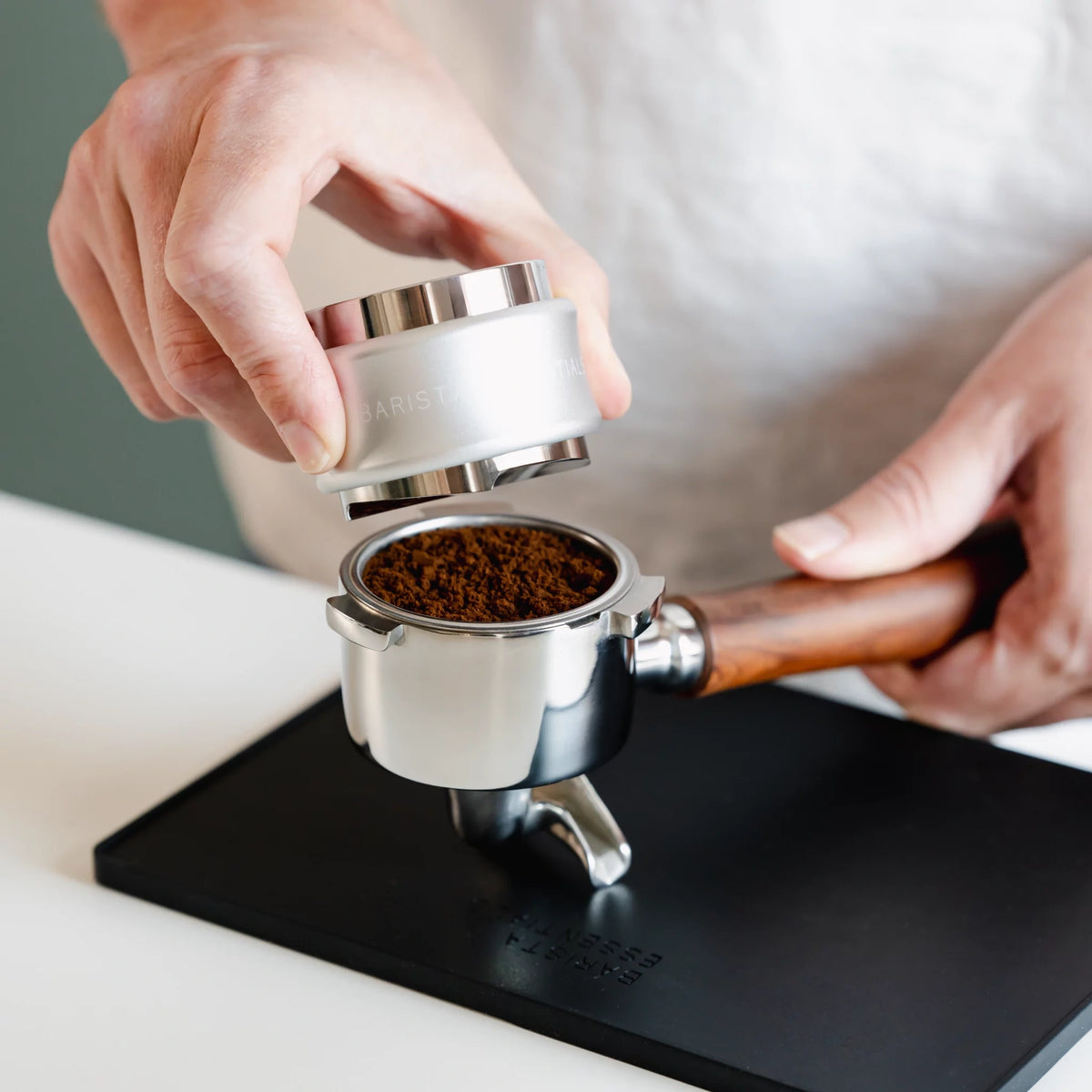 Zilveren combinatietool boven gemalen koffie