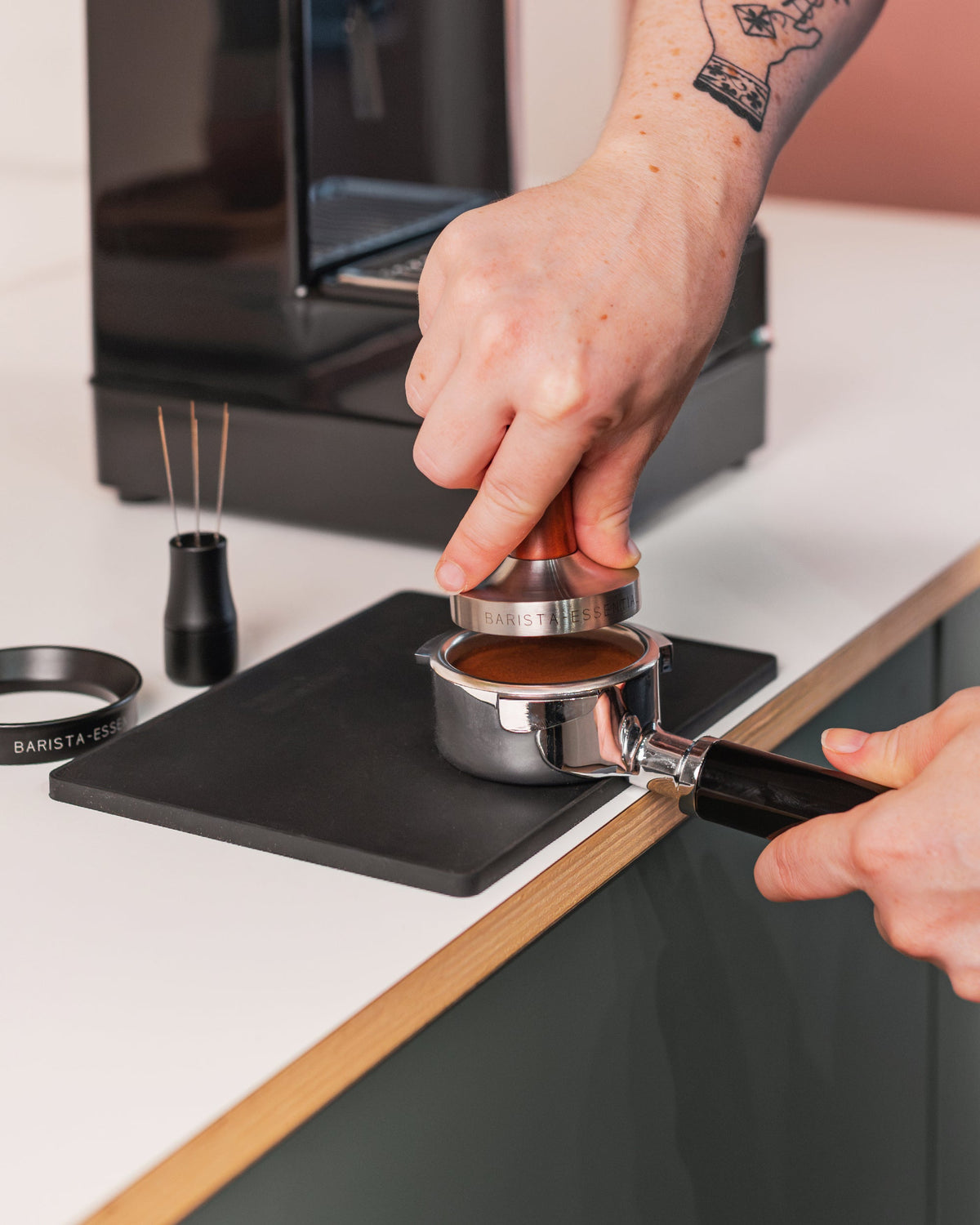 Houten tamper in een filterbakje tijdens het aandrukken van koffie