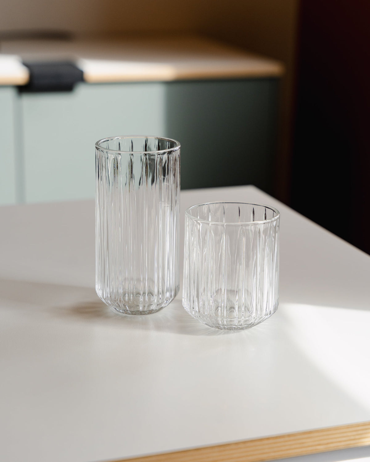 Het lage geribbelde ijskoffieglas naast een hoger koffieglas