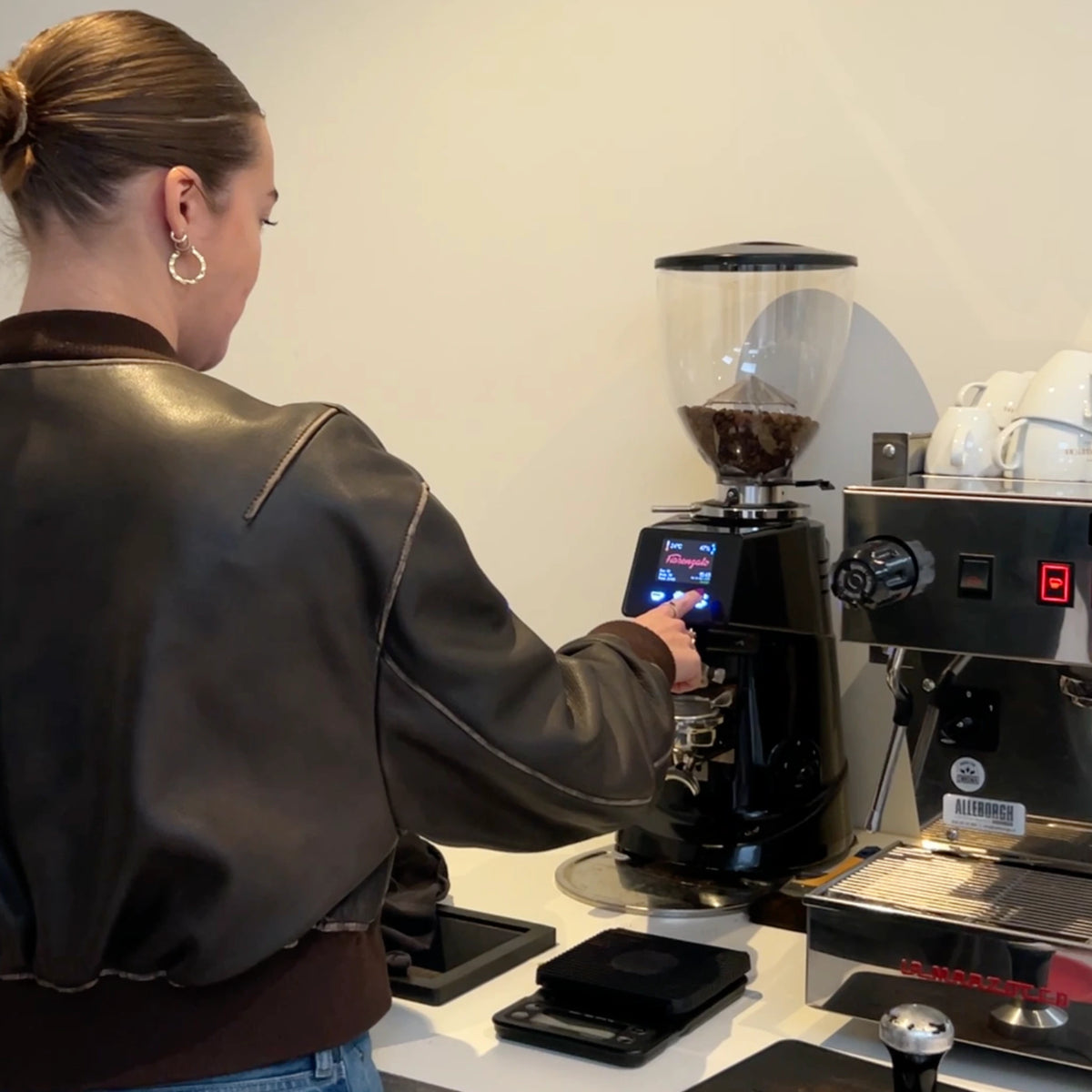 Close-up van een professionele koffiemolen in de horeca, waarbij precisie en afstelling bepalend zijn voor smaak, doorlooptijd en snelheid tijdens espresso service.