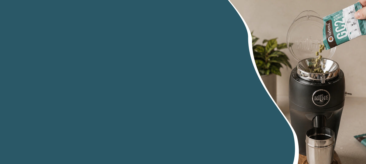 Hero banner van koffiemolen reinigen met reinigingskorrels naast koffiebonen en portafilter voor beter koffiemolen onderhoud thuis