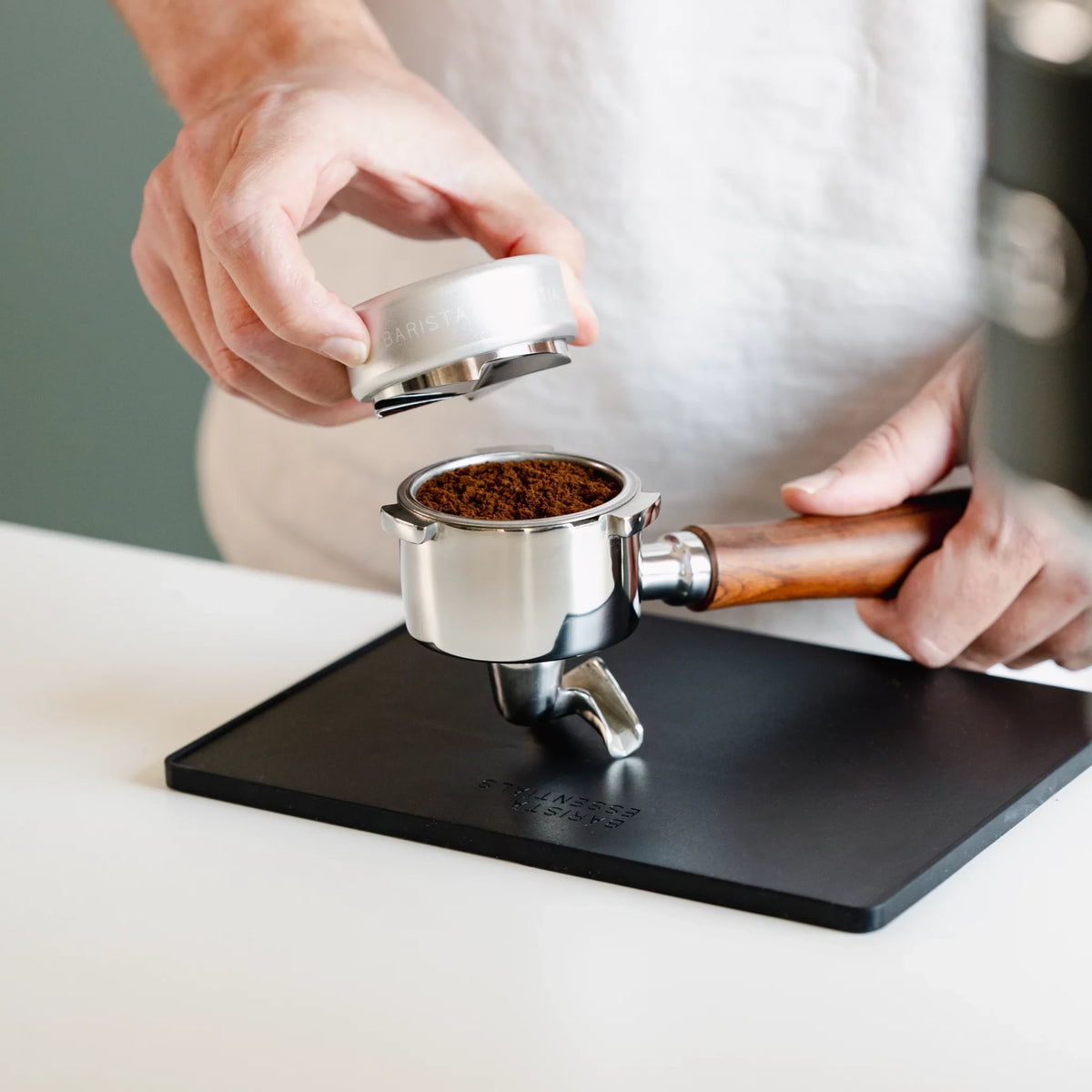 Zilveren koffieverdeler boven een gevuld portafilter