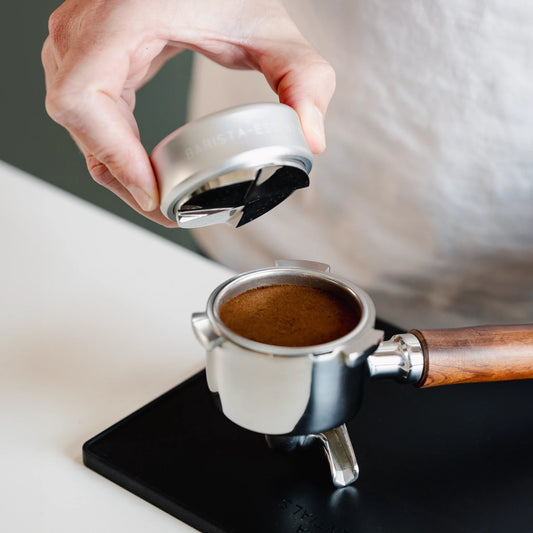 Zilveren koffieverdeler boven een gevuld filterbakje