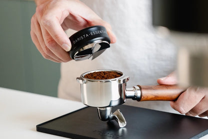 Zwarte koffieverdeler boven een portafilter