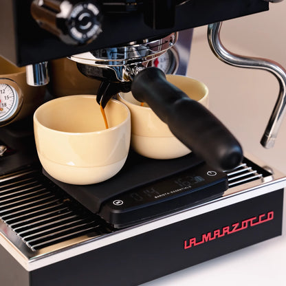 Espresso loopt in een geel kopje op de weegschaal