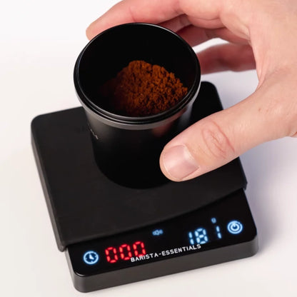 Doseerbeker met gemalen koffie op een miniweegschaal