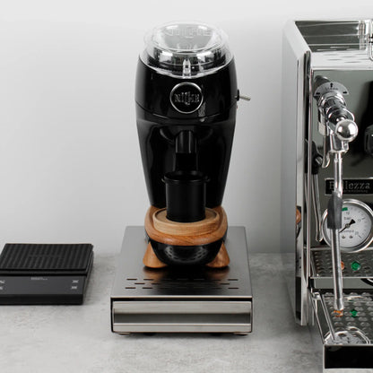 Koffiemolen op een zilveren uitkloplade naast een espressomachine