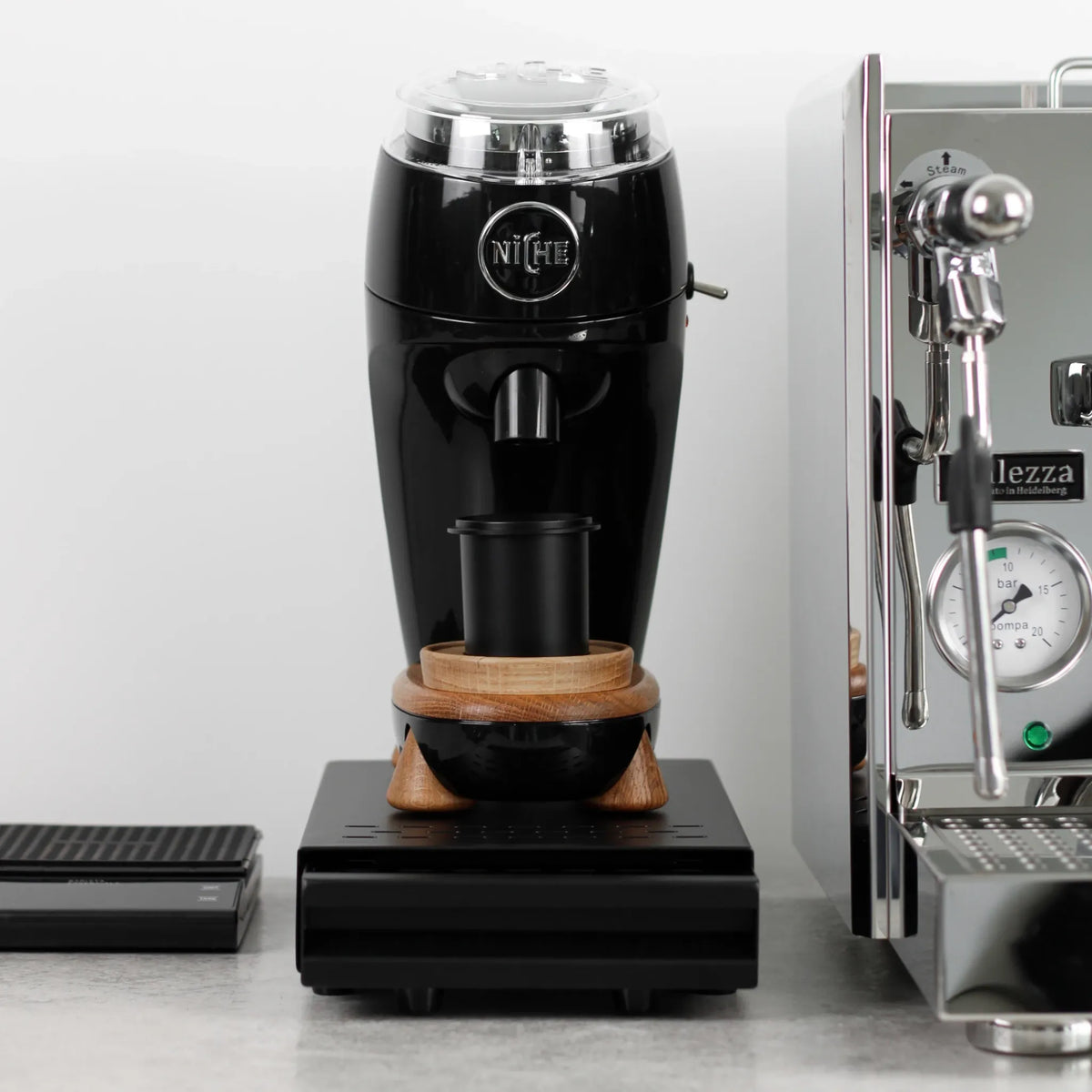 Koffiemolen op een zwarte uitkloplade naast een espressomachine