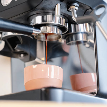 Naked portafilter 54 mm zwart voor Sage: detail van de uitstroom in een roze kopje