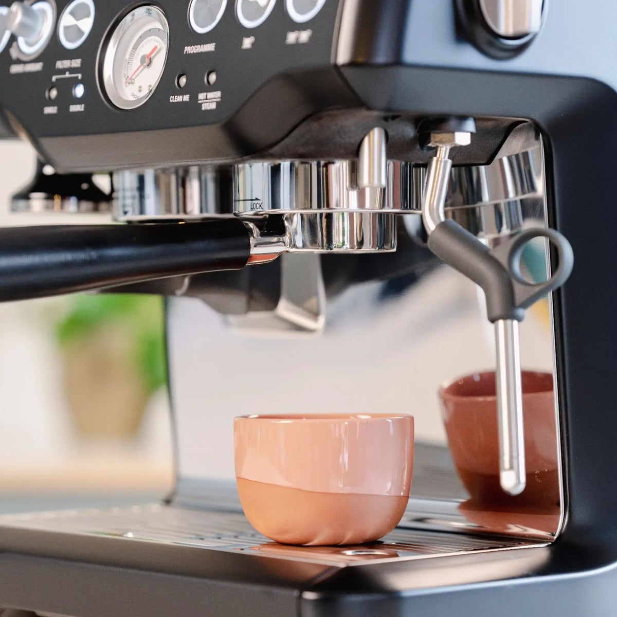 Naked portafilter 54 mm zwart voor Sage: espresso boven een roze kopje