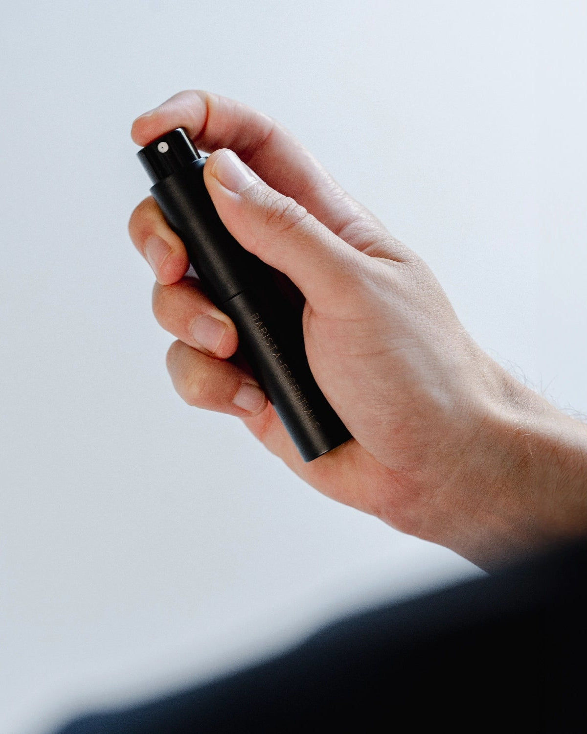 Zwarte RDT-spray in een hand met een vinger op de verstuifknop
