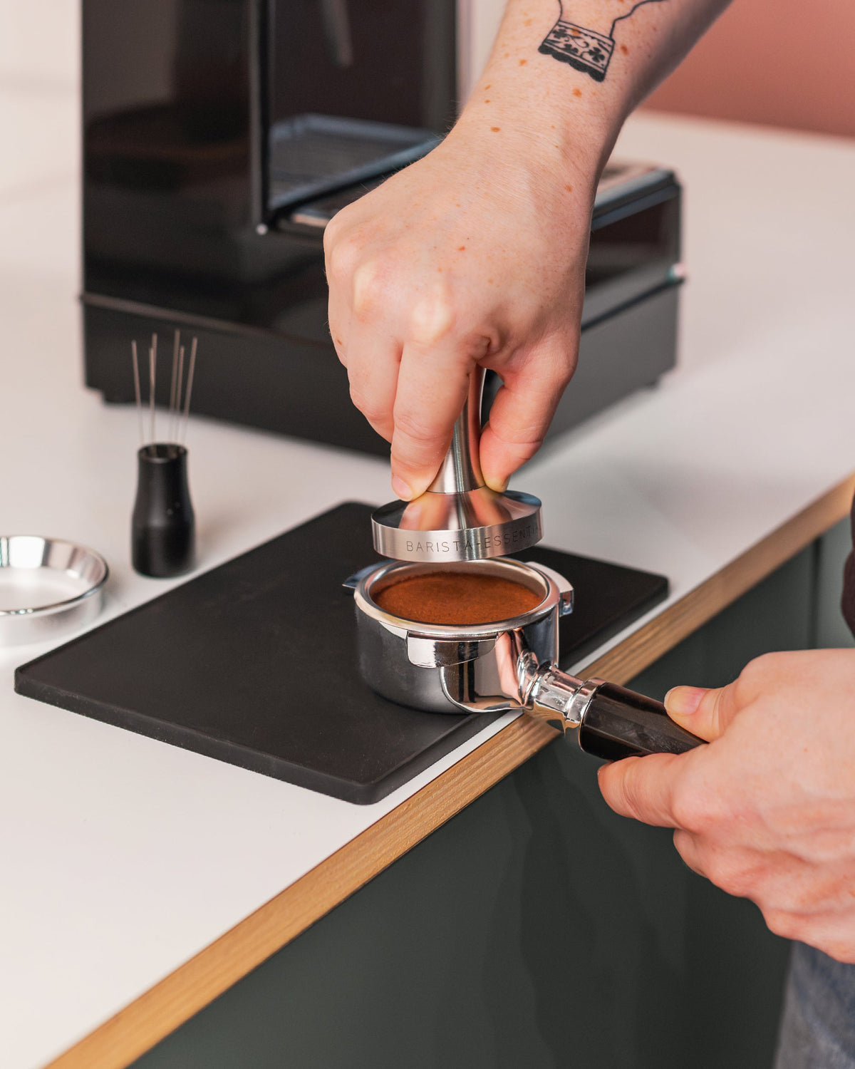 RVS tamper in een filterbakje tijdens het aandrukken van koffie