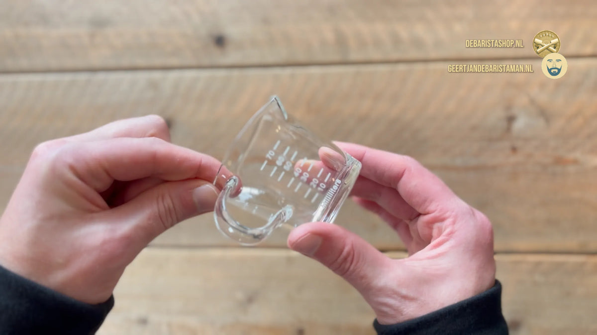 Charger la vidéo : Vidéo d'un verre doseur à espresso transparent avec double bec verseur et graduations jusqu'à 60 ml – s'adapte sous le porte-filtre et sur une balance pour une extraction précise de l'espresso